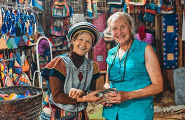 Two women - one local and one tourist - smiling at camera