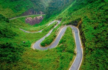 Curved road with switchbacks through green valley