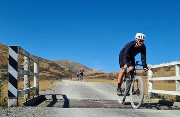 Gravel cyclist on a trail going over a cattle grate