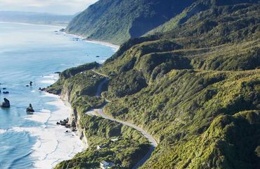 Aerial shot of coastal road winding with the land