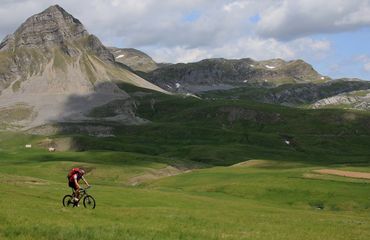 Lone cyclist with epic mountain backdrop