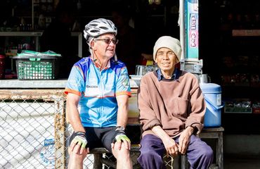 Local man sitting with cyclist from tour