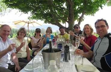 Group of people round a table enjoying wine and lunch