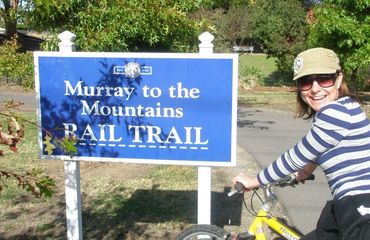 Woman on bike at 'Murray to Mountains Rail Trail' sign