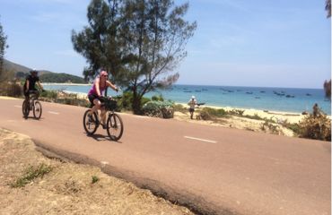 Cyclists riding along coastal road