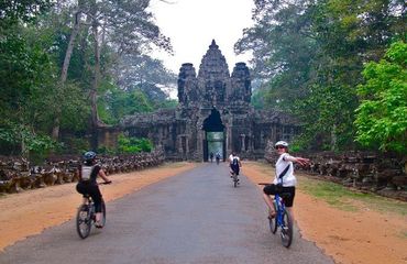 Cyclists riding towards ancient temple