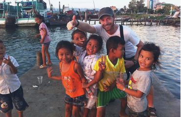 Adult tourist with a group of local children