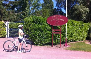 Cyclist in front of chateau sign