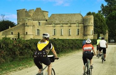 Cyclists riding past historic chateau