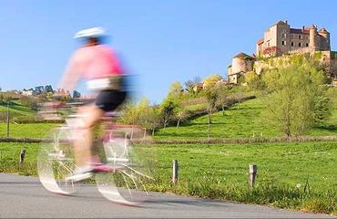Cyclist riding past chateau