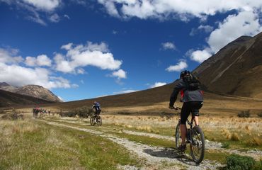 Cyclists riding off road mountain background