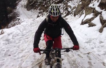 Cyclist riding downhill in snow