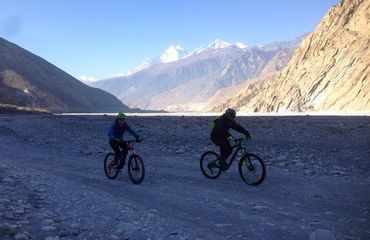 Cyclists riding in valley of mountains