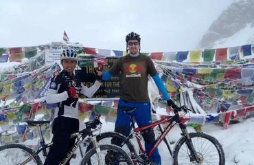 Cyclists standing by colorful flags in the snow