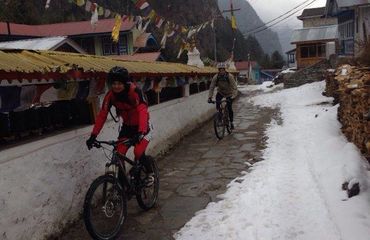 Cyclists riding through village