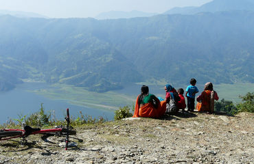 Nepalese women and children sitting by a ridge