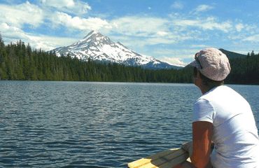 Woman gazing over water to mountain