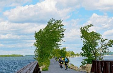 Cyclists riding on trail across lake