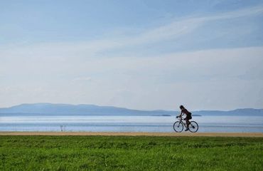 Cyclist riding with lake in background