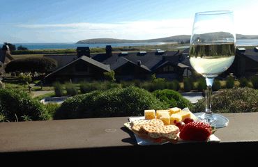 Glass of wine and platter looking out to sea