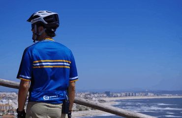 Cyclist looking at Figuera da Foz beach and town