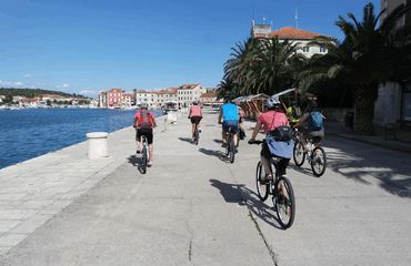 Pack of cyclists riding next to the sea