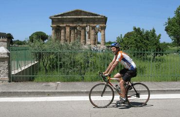 Cyclist riding past ancient ruins