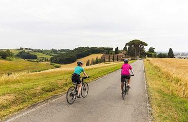 Two cyclists riding along rural road