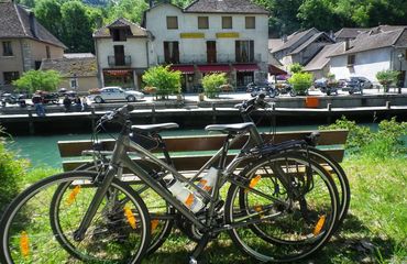 Bikes leaning up against a riverside bench