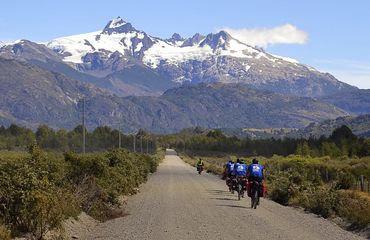 Cycling on road towards snow-capped peaks