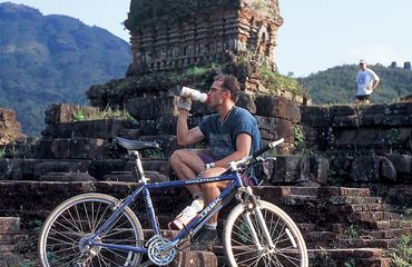 Cyclist taking a break for a drink on some ruins