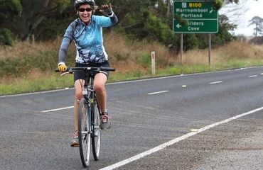 Cyclist waving as they ride by