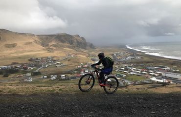 Cycling with mountain and settlement below
