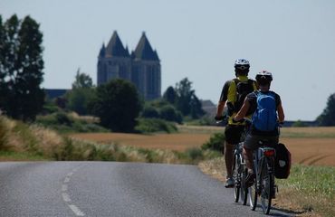 Cycling along a road with a historic building at destination