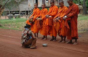 Woman giving alms to monks