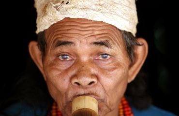 Portrait of a traditional dress man blowing an instrument