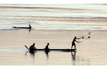 Silhouette of fishing boat at dusk on ocean