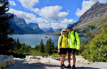 Couple of cyclists standing infront of lake