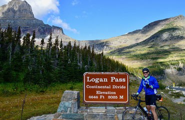 Cyclist by Logan Pass sign