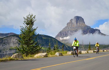 Biking on road past mountains