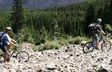 Cycling over rocks with forest in background