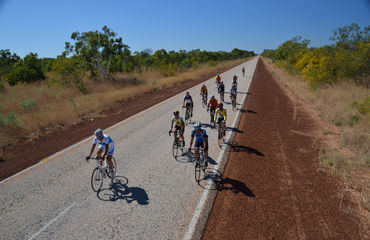 Group of cyclists riding down the road