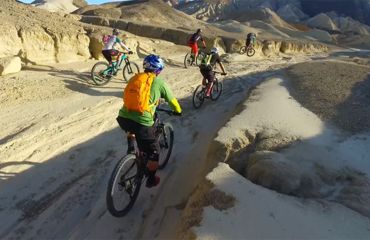 Cyclists on sandy path in desert