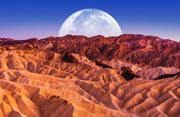 Large moon over the desert mountains