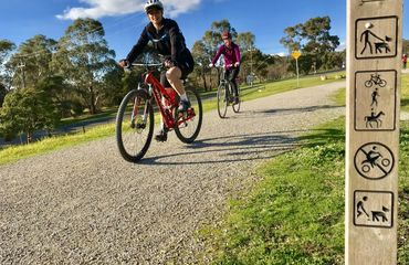 Cyclists on trail with signpost