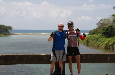 Two cyclists posing infront of sea