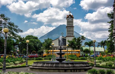 Fountain and town building with volcano in background
