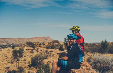 Cyclists sitting in arid landscape