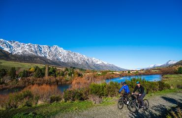 Riding on path with mountains and water behind