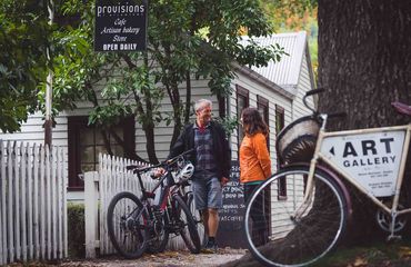 People with bikes standing outside of quaint shop